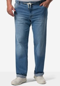 Pantalones de mezclilla azul claro con un corte relajado, cinturilla elástica, cierre con cordón, cinco bolsillos y puños enrollados en los tobillos.