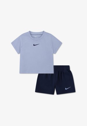 Lyseblå Nike t-shirt med korte ærmer og marineblå shorts med elastisk talje og Nike-logoer på bryst og ben, sat på hvid baggrund.