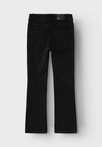 Jeans de mezclilla negra acampanados con una cinturilla de altura media, dos bolsillos traseros y una superficie texturizada. Presenta una etiqueta de marca en la cinturilla.