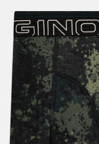 Čierne a zelené boxerské nohavice s vzorom a mäkkým pásom s logom "GINO". Materiál vyzerá hladko a obsahuje detaily šitia.