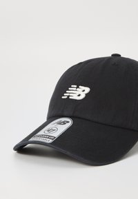 Sort baseball cap lavet af bomuld, med et hvidt broderet logo på forsiden, buet skygge og en justerbar rem bagpå.