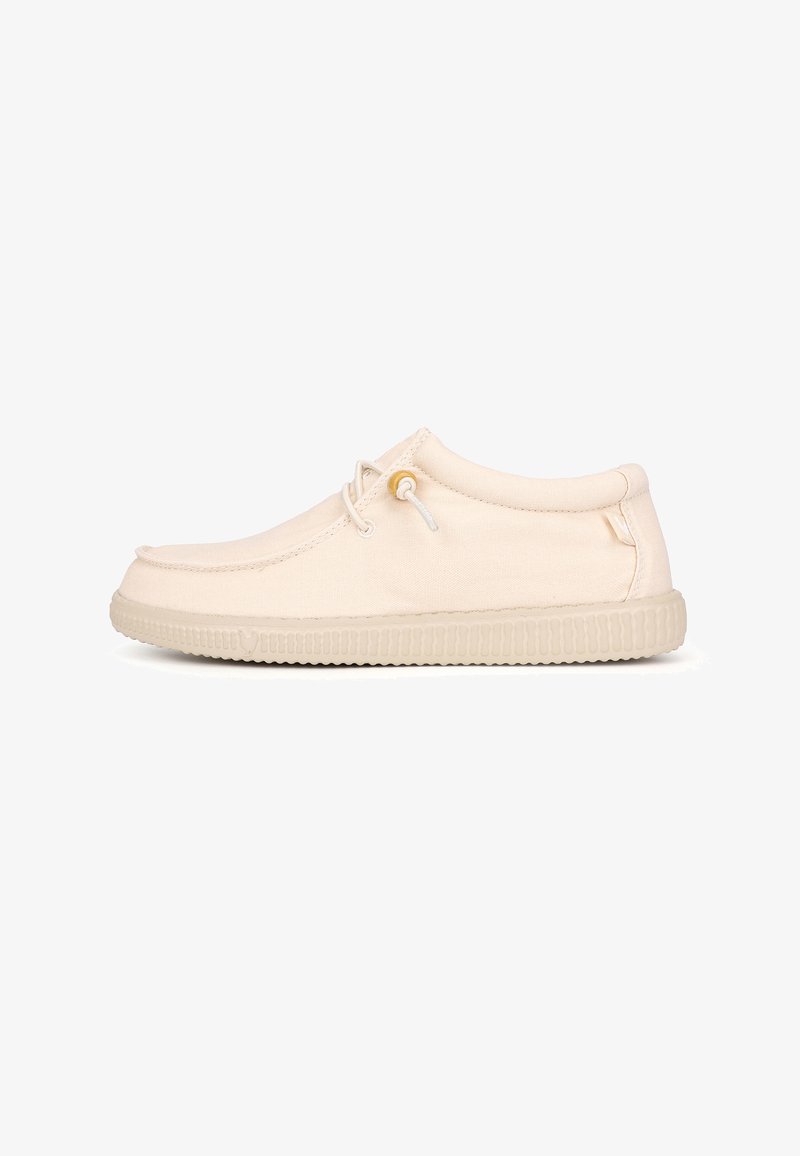Chaussure décontractée beige style mocassin à tige basse avec semelle en caoutchouc et détail de lacets latéraux sur fond blanc.