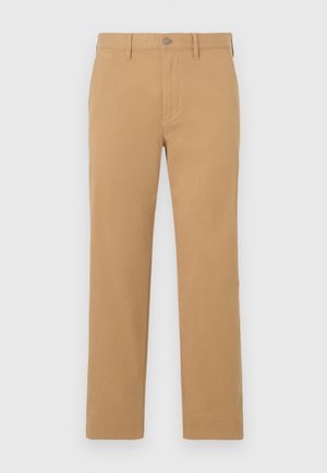 Pantalon beige à jambes droites avec passants de ceinture, fermeture par bouton et poches avant, présenté sur un fond gris clair.