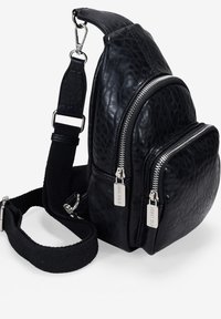 Bolso de cuero negro con textura acolchada, que presenta dos bolsillos con cremallera, una correa desmontable y detalles en metal plateado.