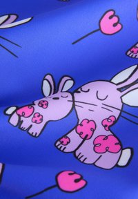 Lilla kangas, mis sisaldab joonistatud jäneseid roosa aktsentide ja südamega elaval sinisel taustal. Pehme tekstuur, mängulised disainielemendid.