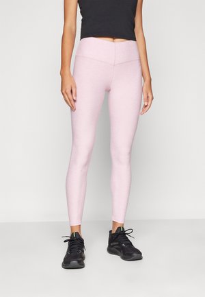 Lys rosa leggings med høy midje og tettsittende design, kombinert med svarte joggesko med grønne detaljer. Glatt tekstur.