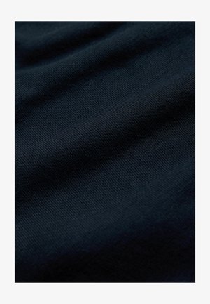 Mörkblå texturerad tyg med mjuk, vävd yta som visar subtila variationer och veck, vilket tyder på ett lättvikts textilmaterial.