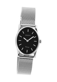 Montre à cadran noir avec bracelet en maille argentée, boîtier ovale, index et aiguilles argentés. Le texte "OOZOO Vintage" apparaît sur le cadran.