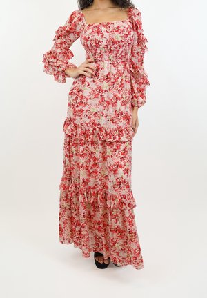 Květinové maxi šaty s volánkovými dlouhými rukávy, nařaseným živůtkem a vrstvenými volánky v odstínech červené a růžové na světlém pozadí.