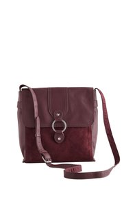 Bordeauxrode leren en suède crossbodytas met klepsluiting, voorzien van een ronde metalen accenten en verstelbare band. Geringe textuur.