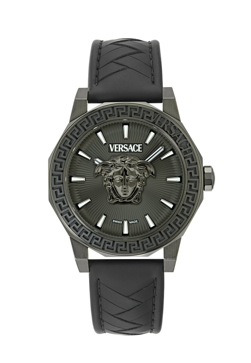Ura Versace z black silikonskim paščkom, osmerokotno kovinsko ohišje, sivo številčnico, ki vsebuje emblem Meduse in izrazite oznake ur. Švicarska izdelava.