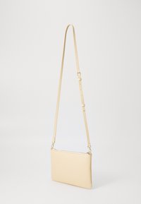 Light beige leather crossbody bag with a textured finish, zip closure, and adjustable strap. Features simple, minimalist design.