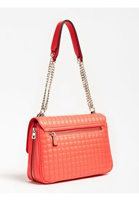 Sac à main corail matelassé avec une poignée supérieure rouge, une bandoulière chaîne argentée et une poche zippée à l'avant. Texture lisse avec motif cousu.