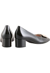 Escarpins en cuir verni noir avec un bout arrondi, un talon carré bas et une finition brillante. Ils présentent un détail découpé à l'avant.