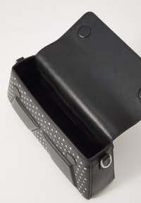 Black rectangular leather handbag with silver studs, open flap showing empty main compartment and magnetic closures.