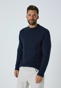 Navy gestrickter Pullover mit Kabelmuster, gerippten Ärmeln und Rundhalsausschnitt. Aus dickem Garn gefertigt, mit lockerer Passform und leicht gewelltem Saum.