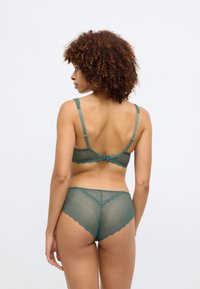 Τιρκουάζ διχτυωτό σουτιέν και ταιριαστά hipster σλιπάκια με φλάτζες. Ρυθμιζόμενες τιράντες, κλείσιμο με γάντζο πίσω και διακριτό σχέδιο.