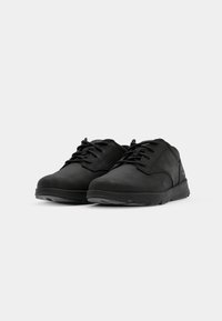 Zapatos negros con cordones, fabricados en material texturizado, con punta redonda y suela de goma flexible. Diseño minimalista con una marca sutil.