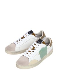 Zapatillas con cuero blanco, acentos de ante en beige y marrón, parches verdes, puntera redonda y cordones blancos. Suela de goma texturizada.