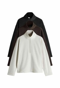 Tričko s fleece materiálom v bielej, hnedej a čiernej farbe, s rozopínacím golierom, dlhými rukávmi a voľným strihom. Mäkká textúra po celom povrchu.