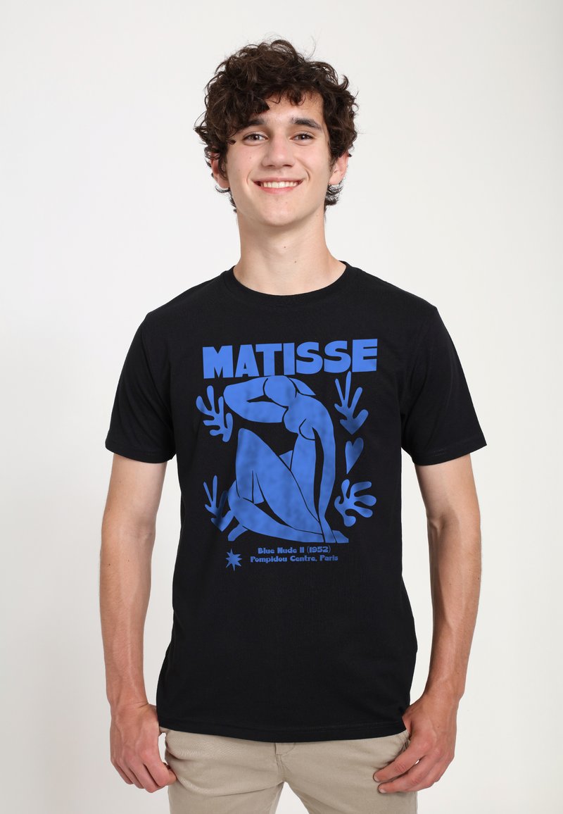 Černé bavlněné tričko s modrou grafickou potiskem postavy a listoví, spolu se slovem "MATISSE" a popisným textem níže.