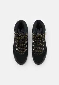 Zwarte wandelschoenen met een bovenwerk van suede en mesh, voorzien van gele en zwarte veters, metalen oogjes en een robuuste rubberen zool.