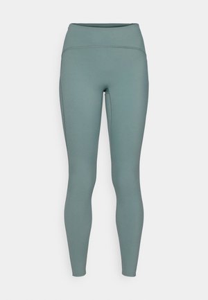 High-waisted leggings in a muted teal color, made from a smooth, stretchy material with subtle seam detailing. Fit is form-fitting throughout.