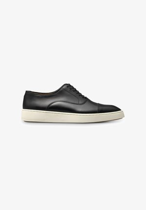 Black leather sneakers with a rounded toe, white rubber sole, and classic lace-up design. Features smooth texture and minimalistic stitching.