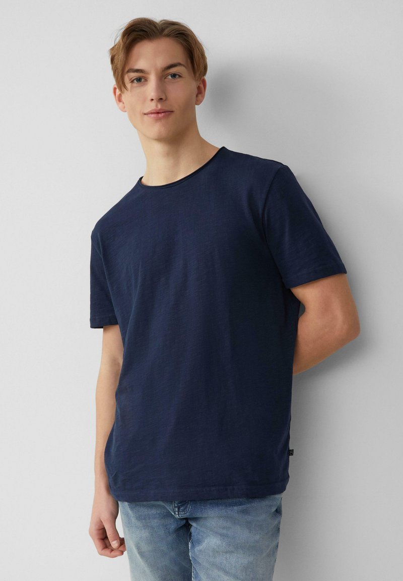 Marineblauwe T-shirt met korte mouwen en ronde hals; gemaakt van lichtgewicht stof; heeft een effen textuur en een losse pasvorm.