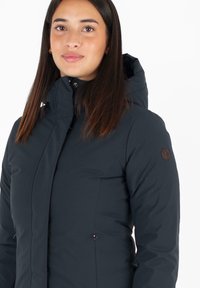 Marine puffer jacket met een hoge kraag, gestructureerde stof, ritssluiting aan de voorkant en zijzakken. Beschikt over een logo op de linker mouw.