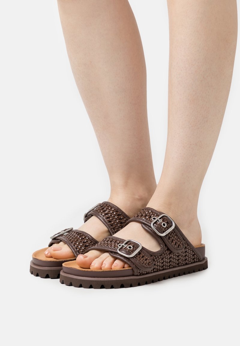 Sandales tissées marron avec deux brides réglables à boucle, dessus texturé et semelle épaisse à rainures pour une meilleure adhérence. Design à bout ouvert.