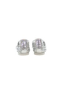 Zapatos de cuero trenzado plateados con un perfil bajo, que cuentan con un acabado suave y detalles trenzados a los lados, suela blanda y parte trasera redondeada.