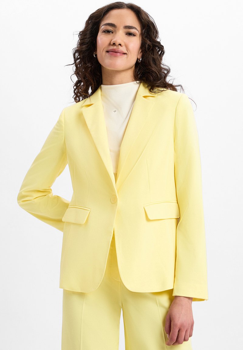 Gelbes Blazer aus glattem Stoff, mit einem Knopfverschluss, eingelegten Revers und zwei vorderen Taschen in taillierter Passform.