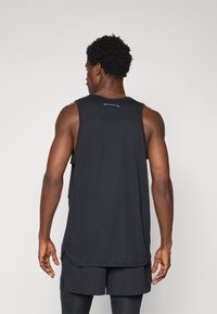 Black athletic tank top, lightweight fabric with a textured pattern, sleeveless design, curved hem, and logo detailing on the back.