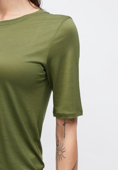 Tricou verde cu mâneci scurte, realizat dintr-un material fin, cu decolteu rotund. Prezintă un design mulat și tivuri cusute.