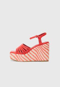 Røde kilehæle sandaler med korslagte stropper og ankelstrop. Plattformen har et tekstureret, stribet jute design i krem og rødt.