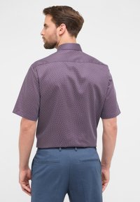 Korte mouwen shirt in donkerpaars met geometrisch patroon, contrasterende lichte accenten en standaard kraag. Licht gewicht stof, ontspannen pasvorm.