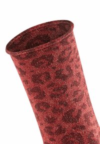 Calzino di tessuto rosso con motivo a stampa leopardata. Il materiale ha una texture luccicante e presenta un bordo superiore arrotondato.