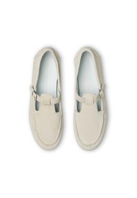 Scarpe in suede beige chiaro con punta arrotondata, design a T, fibbia laterale e cuciture tono su tono. Fodera interna liscia e estetica minimalista.