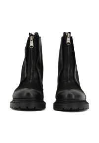 Stivaletti alla caviglia in pelle nera con una texture liscia, dotati di una cerniera fuori centro su ogni lato e una suola spessa in gomma nera.
