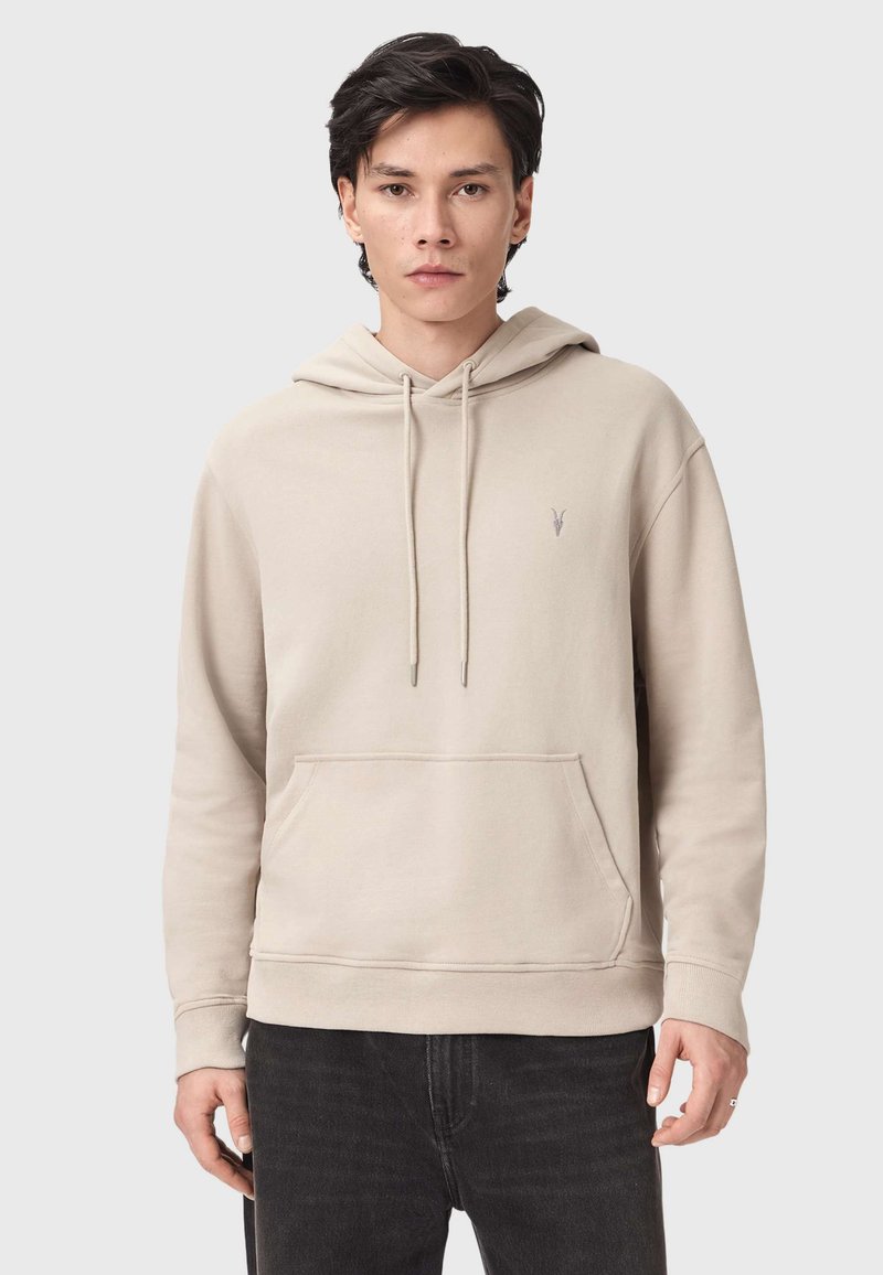 Beige Kapuzenpullover aus weicher Baumwolle. Verfügt über eine Kapuze mit Kordelzug, eine vordere Kängurutasche und eine dezente Logo-Stickerei auf der Brust.