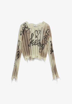 Knit cropped sweater in cream with light brown and black graffiti-style text. Features distressed edges and long sleeves with ribbed texture.