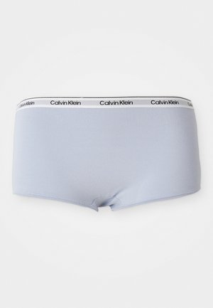 Svetlo modré bavlnené boxerky s čiernobielym elastickým pásom, na ktorom je vytlačené "Calvin Klein" čiernou farbou. Hladký povrch, priliehavý strih.