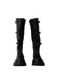 Bottes hautes en cuir noir avec semelles épaisses, lacets à l'avant et trois boucles latérales réglables sur chaque botte.