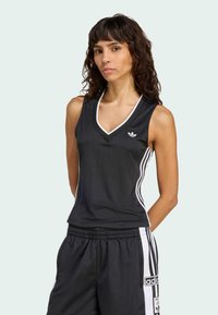 Svart ärmlös atletisk topp med V-hals, med vitt kantband och vertikala ränder, tillverkad av ett mjukt tyg. Adidas-logga på bröstet.