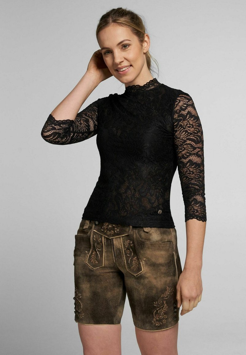 Schwarzspitze-Oberteil mit Dreiviertelärmeln und gewelltem Ausschnitt, kombiniert mit braunen bestickten Shorts.