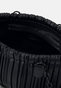 Borsa a tracolla in pelle nera con design plissettato, apertura superiore, tasca interna con zip e un accento decorativo a catena. Bordature curve e superficie liscia.