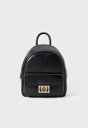 Melna ādas mini mugursoma ar priekšējo rāvējslēdzēja kabatu un zeltaini Love Moschino logo plaketi uz baltā fona.