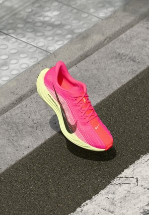 Chaussure de course Nike avec un dessus rose vif et orange en matériau mesh, une semelle jaune et un design épuré avec un accent de logo sombre.