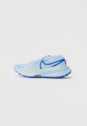 Zapatillas deportivas de un azul claro con parte superior de malla, acentos en azul, entresuela moteada y suela Vibram. Cuenta con un lazo en el talón para facilitar su uso.